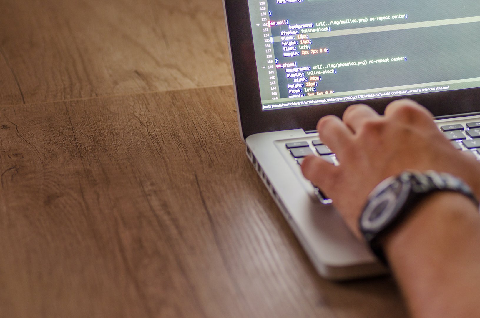 Macbook coding on wooden table