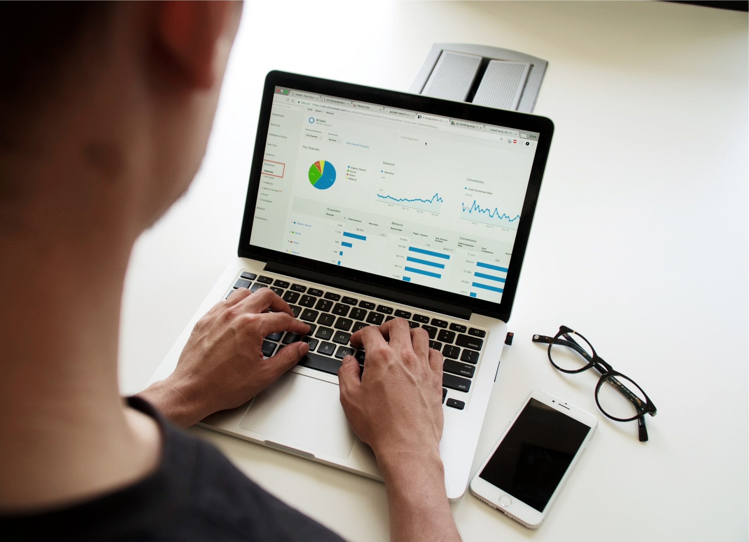 Macbook med analyse data på skærmen og betjenes af person